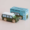 A small green classic toy car sits next to its blue box, labeled “No. 27 GT150 Archie | Made in England” with vehicle illustrations and limited edition details. Perfect for imaginative play, the toy features a white roof and wooden wheels, capturing the timeless charm of a beloved childhood collectible.