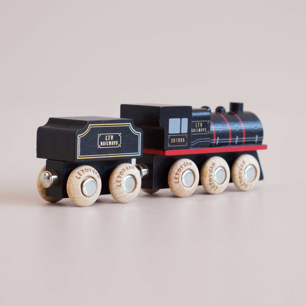 A small wooden toy train, the No. 49 GT295 Francis, painted black with red and white details; this classic locomotive-inspired steam train toy has six wheels and “LTV RAILWAYS” printed on the side, and is made in England.