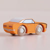 A small, orange wooden racing car with black accents and the name “No. 22 GT125 Cami | Made in England” printed on its wooden wheels sits on a light surface.