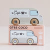 A wooden coffee van painted as a café, featuring “Café” and a cup design, sits atop its matching box labeled “No. 11 GT65 Coco | Made in England.” Perfect for thoughtful gifting, this charming toy encourages imaginative storytelling. The box displays logos for sustainable wood, made in England, and child-safe paints.