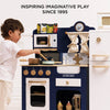 A young child plays with a blue and white Pots & Pans Kitchen Accessories toy cooking set.