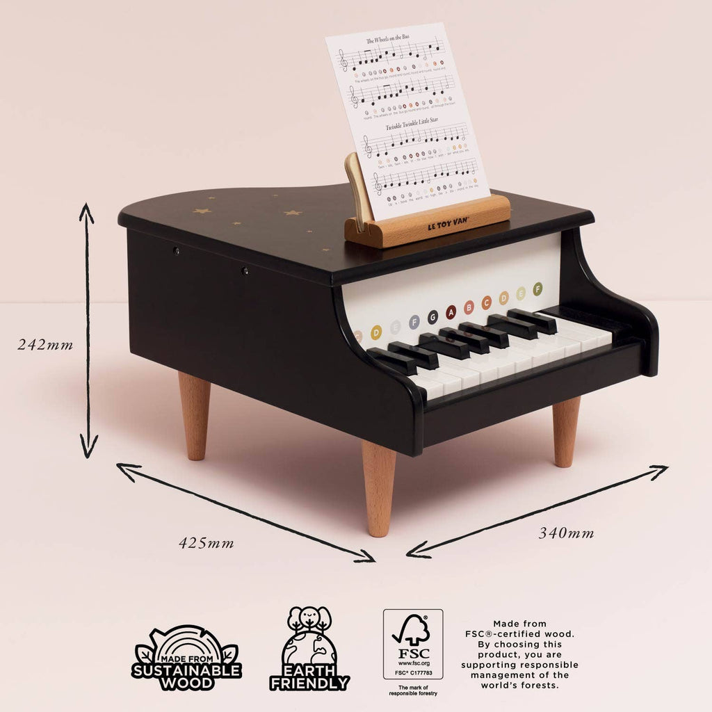 The Wooden Grand Piano Toy is a small black piano with wooden legs, labeled keys, and sheet music on a stand. Measuring 242mm high, 425mm wide, and 340mm deep, it’s made from sustainable FSC-certified wood to inspire early musical skills.