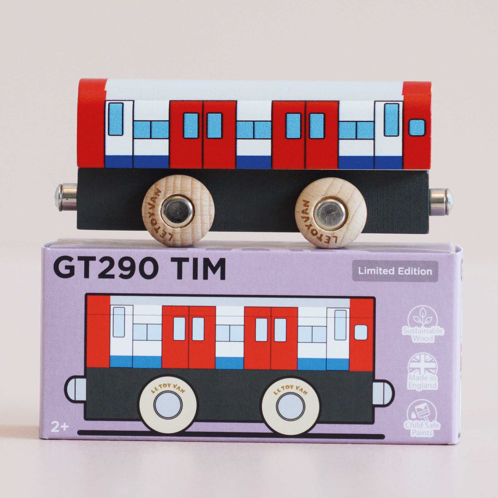 A wooden toy train with a red, white, and blue design sits on top of a purple box labeled “No. 48 GT290 Tim | Made in England.” Perfect for imaginative play inspired by metro transport adventures, the box also features an illustration matching the train.