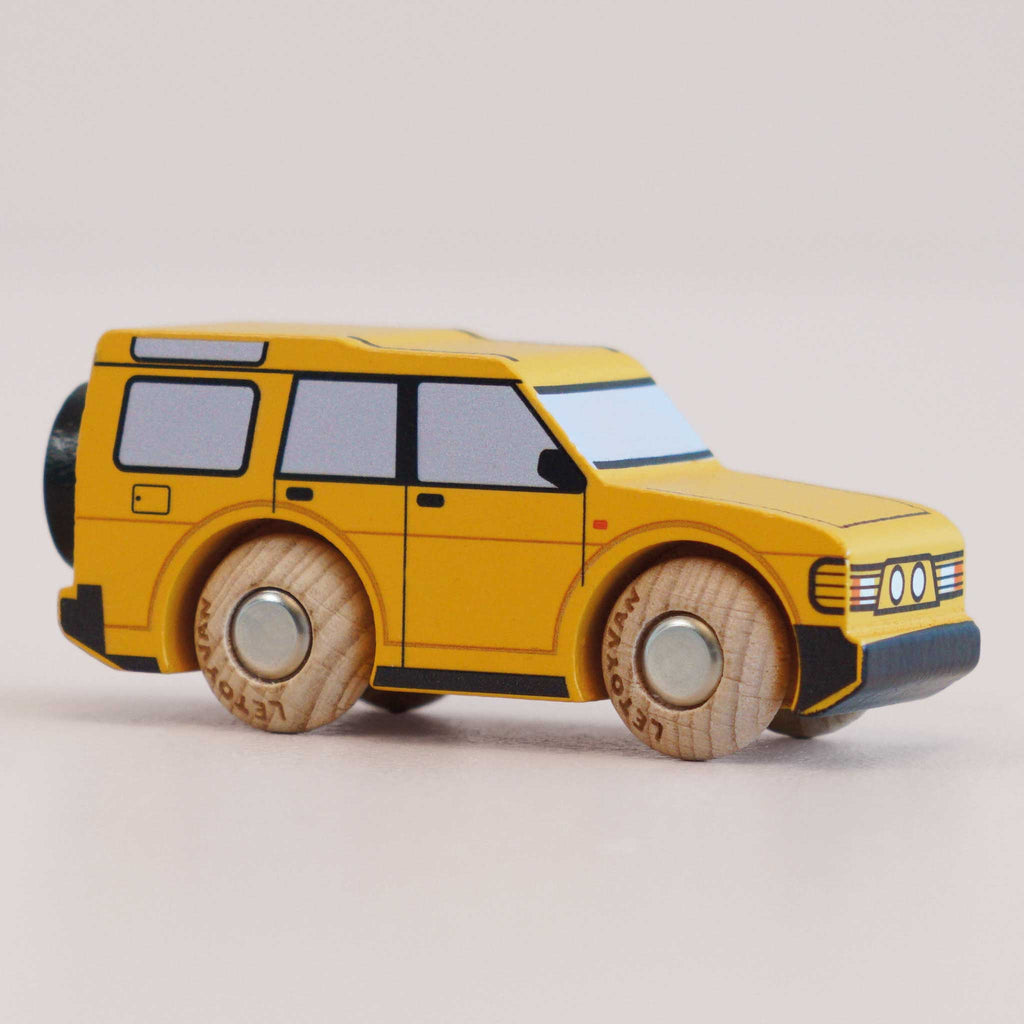 The No. 35 GT195 Riley | Made in England is a yellow wooden 4x4 toy car featuring wooden wheels, black-tinted windows, and simple printed details, photographed on a plain light background—perfect for little ones who love adventure toys and off-road vehicles.
