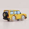The No. 35 GT195 Riley | Made in England is a yellow wooden toy SUV featuring black and white details, four sturdy wooden wheels, and a black spare tire mounted on the back. Photographed against a light background, it’s perfect for imaginative play and inspired by classic off-road vehicles.