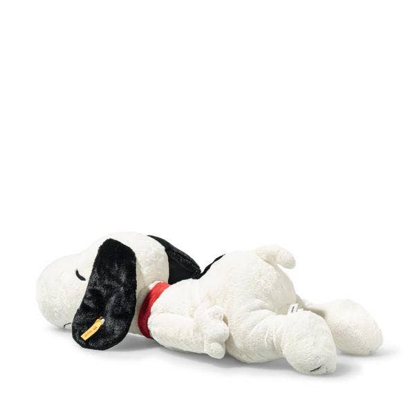 The Steiff XL Snoopy Lying Down 16" plush features Snoopy on his stomach with closed eyes, black floppy ears, a red collar, and a relaxed pose set against a plain white background.