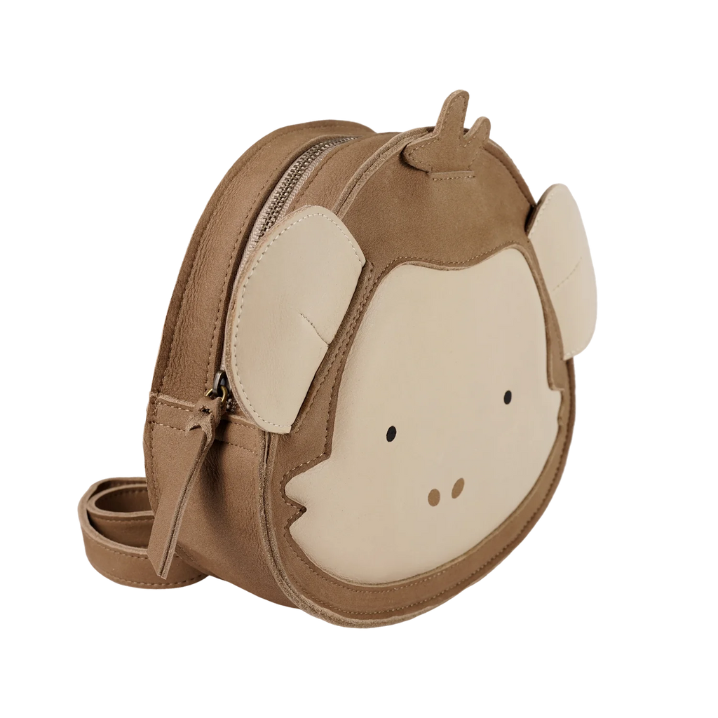 The Donsje Leather Kapi Backpack - Monkey is a small, round brown leather bag with a cartoon monkey face, beige ears, simple eyes and nose details, zipper closure, and matching strap in an animal-inspired design.