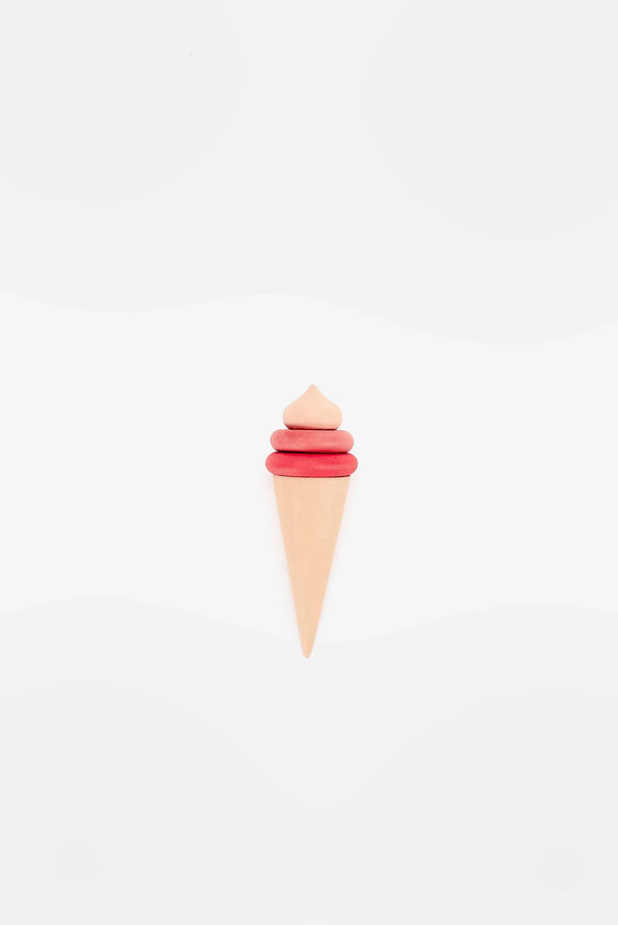 A minimalist artistic representation of a Handmade Ice Cream Cone made from cutout paper in pastel colors, with a pink scoop and a tan cone on a white background with faint circular patterns.