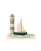 Sabo Concept Sea Adventure Set features a wooden lighthouse and sailboat on a wavy base in blue, teal, and natural wood—perfect for imaginative ocean play against a plain white background.