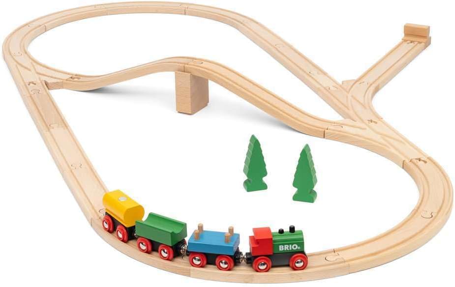 Celebrate the BRIO World 65th Anniversary Train Set, featuring a classic wooden looping track, red, green, and yellow train, two green trees, and a small bridge support.