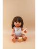 A doll with brown hair, dressed in a white onesie featuring a crescent moon design, sits on a beige surface. It holds a magic spoon and is placed beside the small jar labeled "Tiny Tummies- Banana Jelly food - Tiny Harlow," filled with orange-colored food, ready for the doll to enjoy.