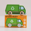 A green wooden recycling truck, labeled “No. 36 GT200 Rudy | Made in England,” sits atop an orange box adorned with white recycling symbols and red-striped accents. Both the truck and the box highlight eco-friendly toy features, inspiring sustainable play for young environmentalists.