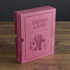 The Board Game: Candy Land Vintage Bookshelf Edition features a pink box with gingerbread and candy designs, displayed on wood—a charming addition to any preschooler's game collection.