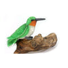 The Hummingbird Stuffed Animal features green and white felt, an orange throat, a gray beak, and sits on lifelike brown wood—showcasing the detailed craftsmanship typical of hand-sewn plush from brands like HANSA.