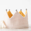 A soft, Reversible Crown with a pale pink base and yellow pointed tips topped with gray pompoms, displayed on a white background.