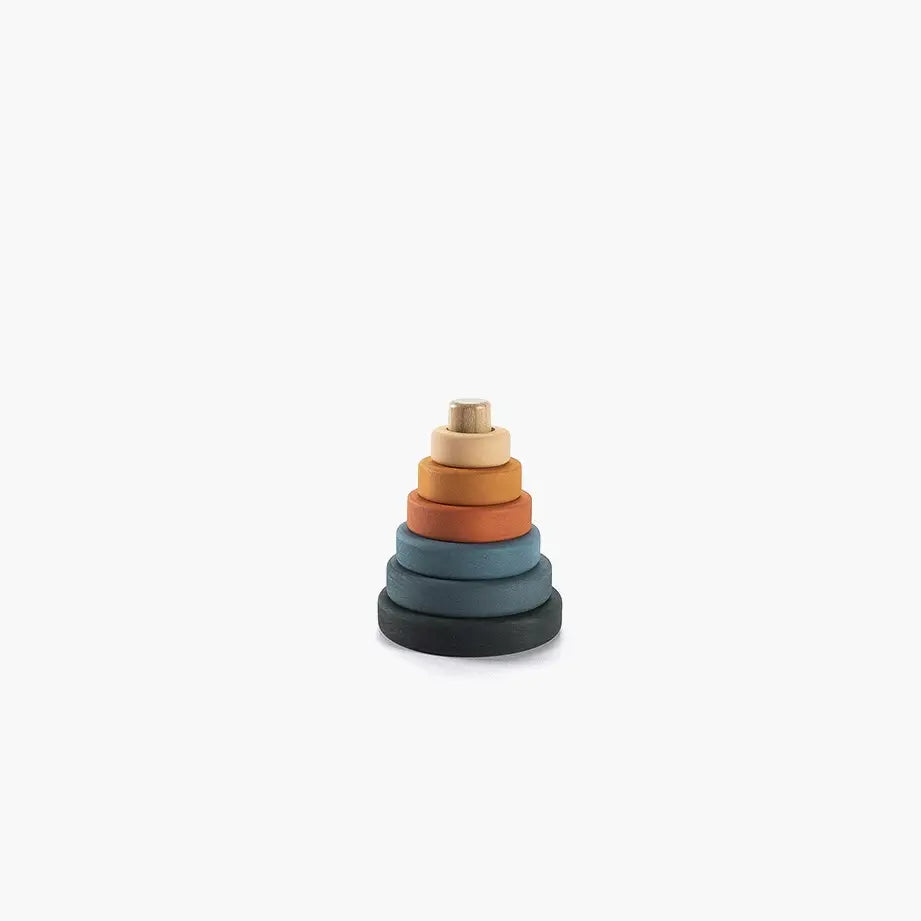 A stack of colorful, graduated rings forming a pyramid, with the largest at the bottom in dark blue, ascending to the smallest in beige at the top, against a white background. This stacking toy is Mini Wooden Pyramid Stacker - Tropics.