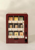 The Wooden Play Vending Machine is a red wooden pretend playset with three shelves, white knobs, and illustrated fruit and vegetable blocks—like pineapple, lemon, and carrot—that help kids build motor skills.