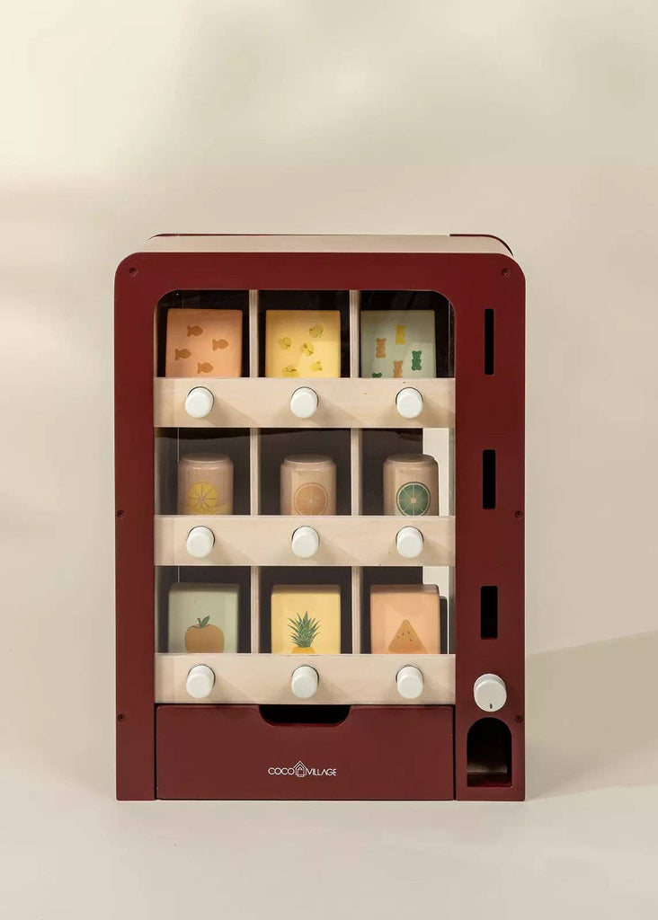 The Wooden Play Vending Machine is a red wooden pretend playset with three shelves, white knobs, and illustrated fruit and vegetable blocks—like pineapple, lemon, and carrot—that help kids build motor skills.