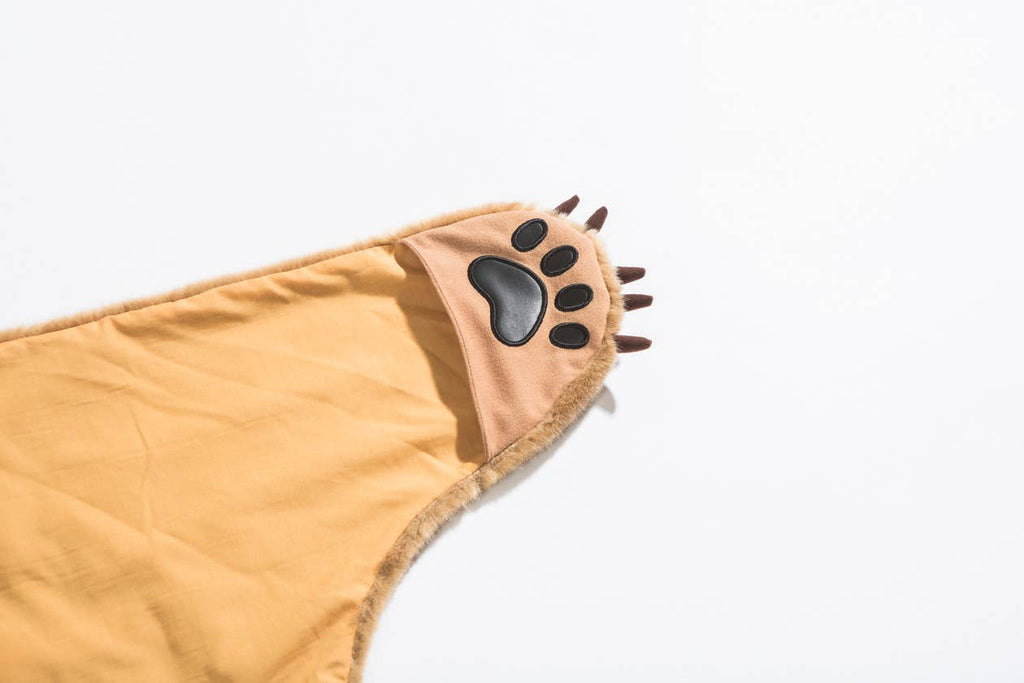 A yellow faux fur Costume - Tiger paw with brown claws and a black paw pad is laying on a white surface.