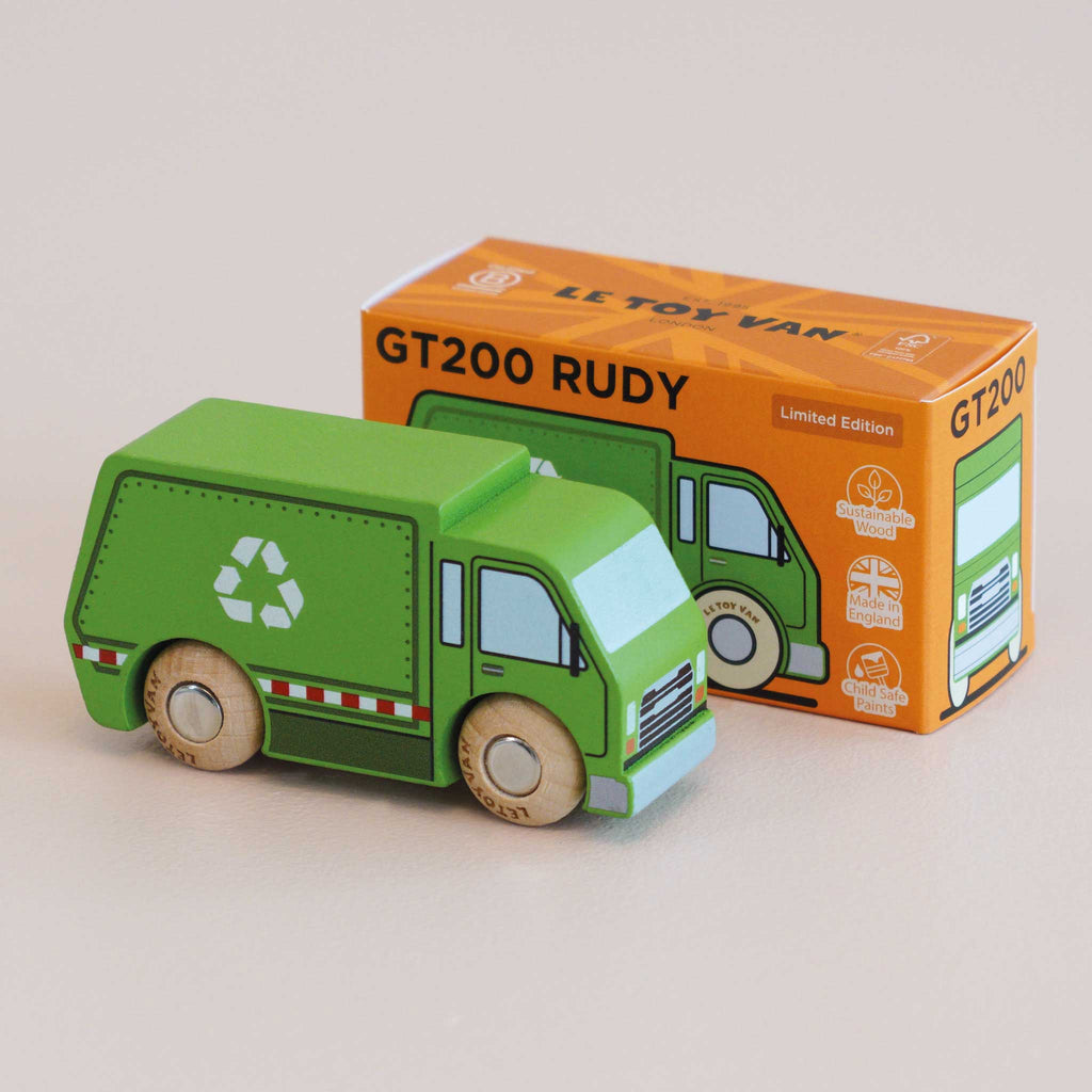 A small green wooden recycling truck with a white recycle symbol stands in front of its orange box labeled “No. 36 GT200 Rudy | Made in England” and “Le Toy Van.” Perfect for sustainable play, the box features an illustration of the truck alongside various icons.