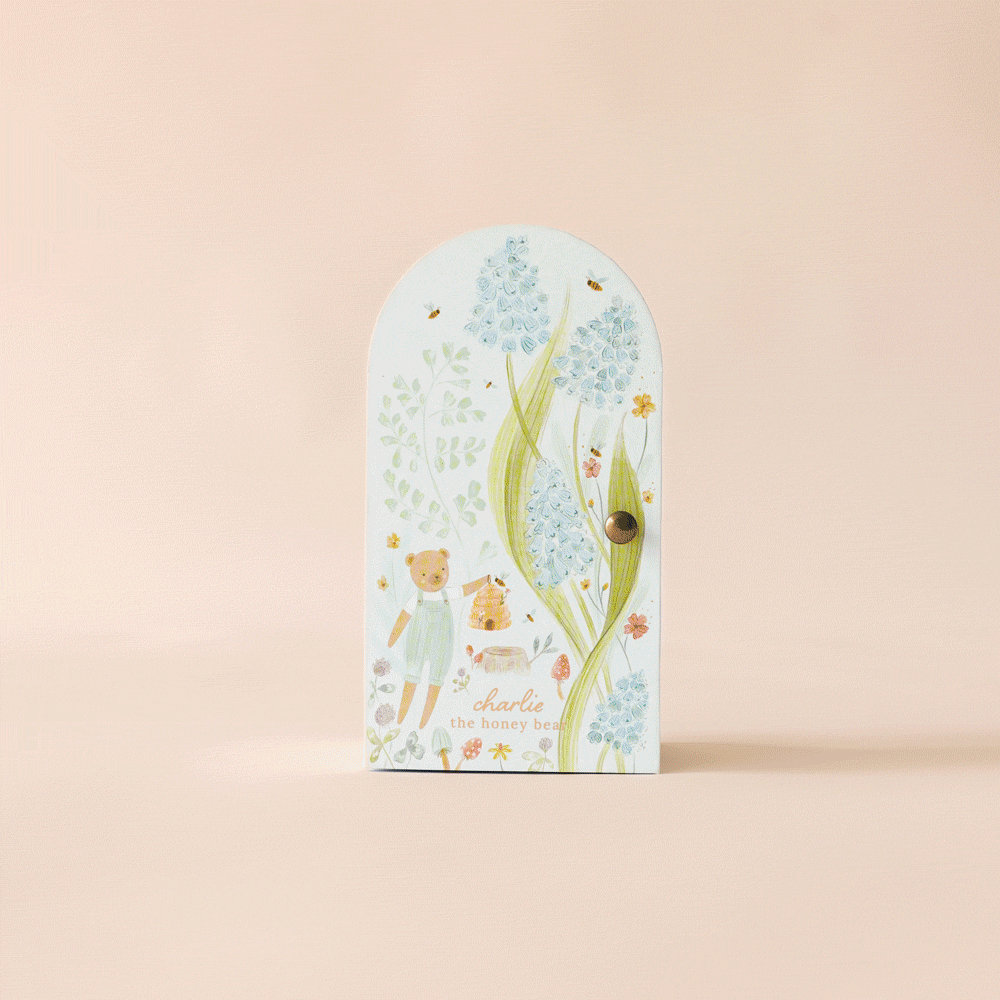 Inspired by fair trade artistry and Peruvian handmade charm, this door features a drawing of Cuddle + Kind Tiny Charlie the Honey Bear with flowers.