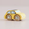 A No. 10 GT60 Fifi vintage toy wooden car, made in England, featuring a small yellow body, black windows and roof, and large natural wood wheels, sits on a plain light surface.