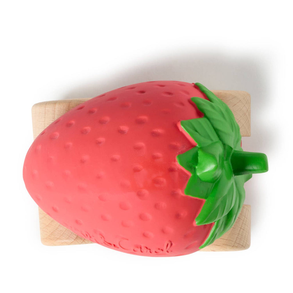Sweetie The Strawberry Baby Car, an eco-friendly toy shaped like a large red strawberry with green leaves on a small wooden block, is shown against a white background.