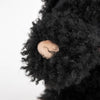 Close-up of Pull-Along Walter, a plush toy with curly black fur, featuring a beige fabric nose and sturdy wooden wheels—perfect as a charming pull-along companion.