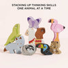 Nine vibrant wooden animal blocks—including butterfly, flamingo, llama, fox, sloth, toucan, leopard, and lizard—from the Andes Stacking Animals & Bag are stacked on a white background. Text: “Stacking up thinking skills one animal at a time!”.