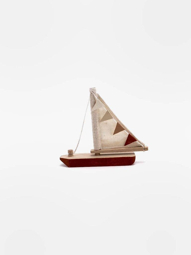 The Handmade Small Wooden Boat, crafted in Ukraine from beech, features a white and brown hull with a cloth sail and small triangular flags. Painted with non-toxic paint, this charming piece is set against a plain white background.