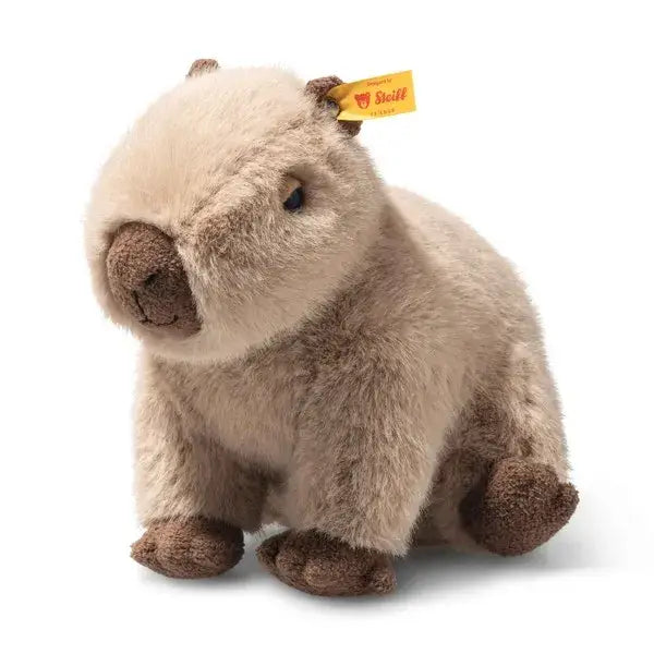 The Steiff Chip Capybara is a plush toy with soft light brown fur, dark brown nose and feet, and a yellow Steiff tag in its ear. It sits upright on a white background, exuding the trademark charm of the Chip Capybara collection.