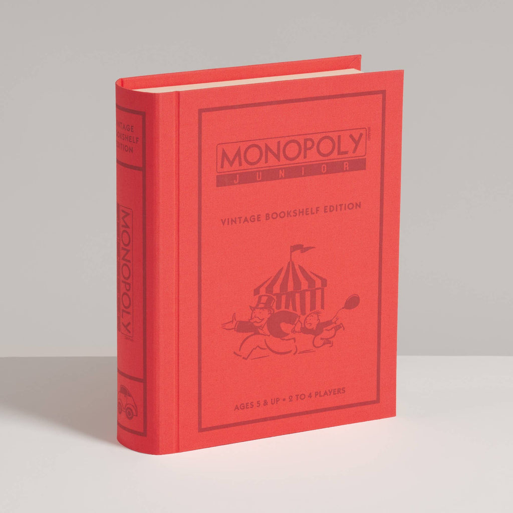 A red, book-shaped Monopoly Junior Vintage Bookshelf Edition game box featuring a circus tent illustration on the cover and spine.
