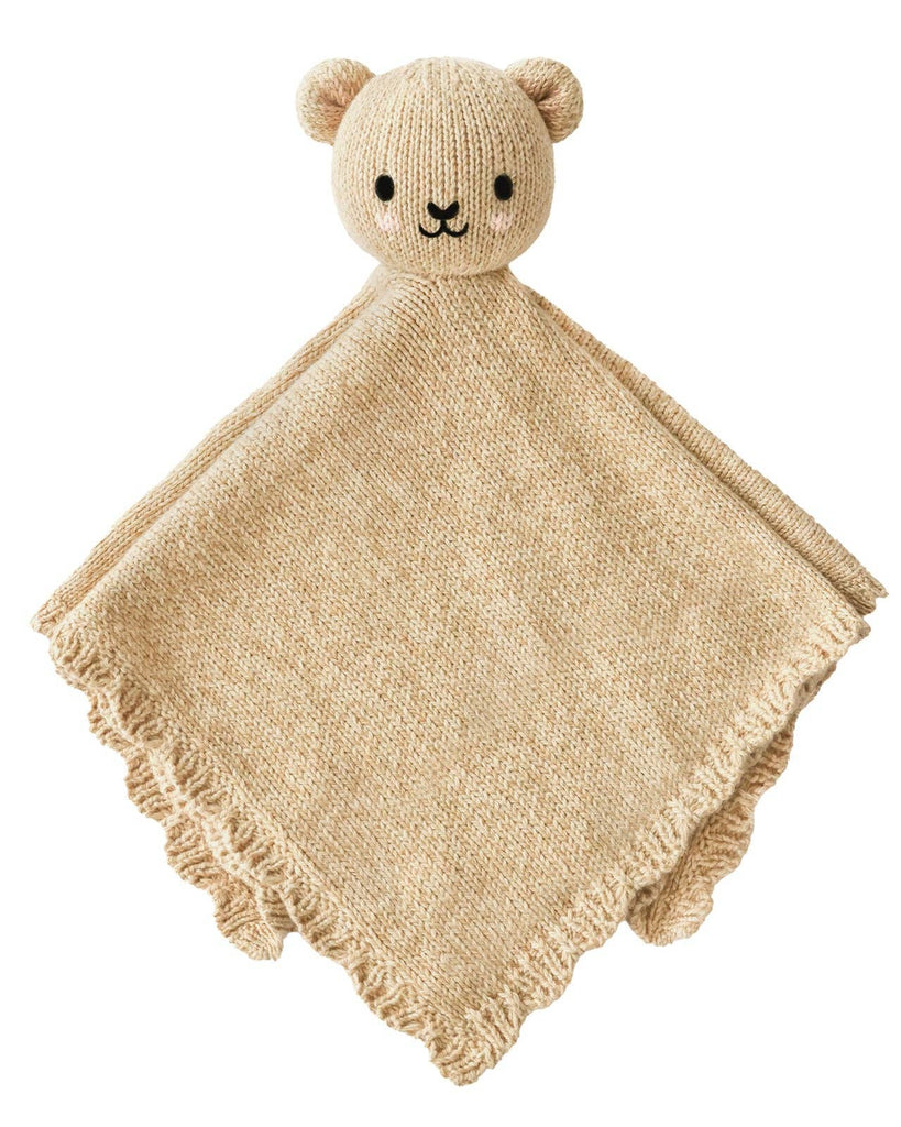 The Cuddle + Kind Organic Cotton Baby Bear Lovey (Honey) is a beige hand-knit baby blanket with a plush bear head, black eyes and nose, round ears, and a scalloped edge—an adorable, fair trade baby gift.