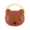A cute circular Donsje Leather Hair Tie - Bear designed to resemble a bear's face, with stitched ears and features, and a solid beige ring attached at the top.