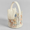 The Coral & Tusk Easter Parade Basket features an embroidered bear, sheep, and rabbit in costumes, with a leaf-shaped cutout top and handle. Earthy embroidery tones are highlighted by subtle blue accents.