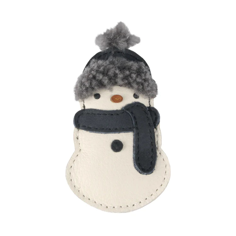 A Donsje Wonda Hairclip | Snowman made of fabric, featuring a grey and black hat with a pompom, a matching scarf, and a white body with stitched details.