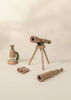 A Wooden Tripod Telescope – 15x Zoom on a light background is crafted from smooth natural wood with green accents, perfect for imaginative pretend play. The set also includes wooden binoculars, a spyglass, and a bell.