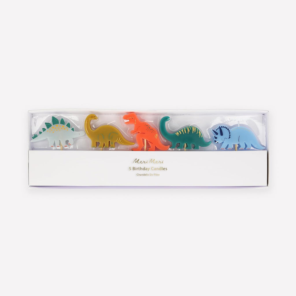 A pack of five Meri Meri Dinosaur Candles in various colors, displayed in a clear plastic box with a white label that reads "meri meri 5 birthday candles.