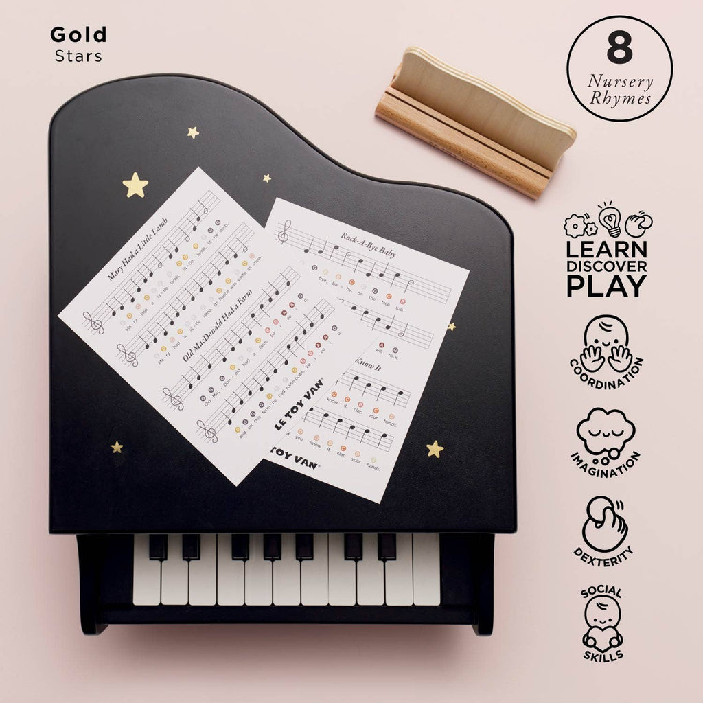 The Wooden Grand Piano Toy is black with white keys and gold stars, made from FSC-certified wood. Two nursery rhyme music sheets rest on top. Icons on the right show it develops learning, coordination, musical, imagination, and social skills.
