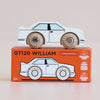 A retro wooden toy car with black detailing, the No. 21 GT120 William by Le Toy Van, sits atop an orange box labeled “GT120 WILLIAM Limited Edition.” Its packaging prominently features icons indicating sustainable wood, child-safe paints, and its “Made in England” origin.