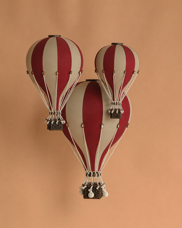 Three decorative Hot Air Balloon - Burgundy models with woven baskets hang against a plain tan background, making ideal lightweight ornaments or handmade decor for children's rooms.