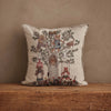 The Coral & Tusk Tree of Fun Pillow features a cheerful embroidered design of a fox, bear, and rabbit playing around a tree on beige fabric, displayed on a wooden surface.
