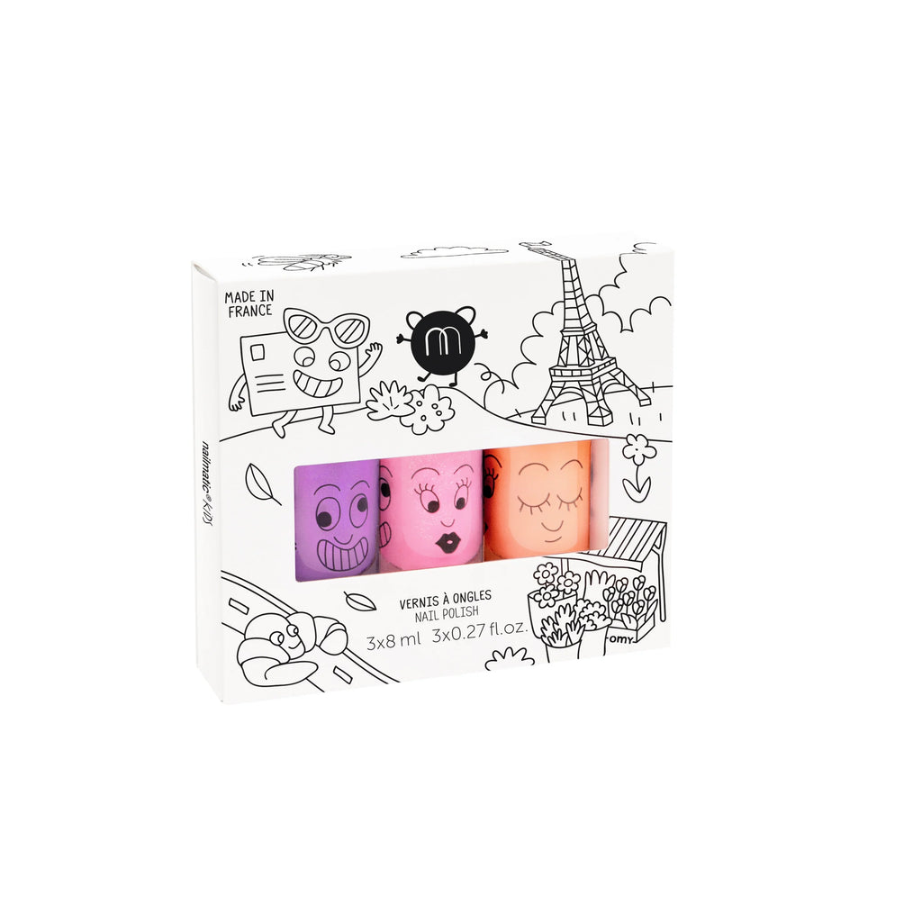 A box featuring four cartoonish, water-based Nailmatic - 3 Nail Polish Set - Paris bottles with playful faces, themed illustrations including an Eiffel Tower and flowers, and text indicating 3 x 8 ml sizes, made in