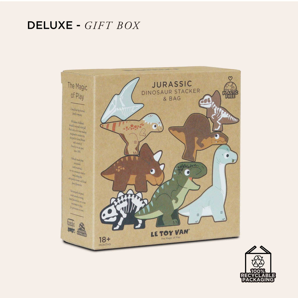 The beige cardboard box with cartoon dinosaurs, including a T-Rex and Stegosaurus, introduces the "Jurassic Stacking Dinosaurs." Celebrating "The Magic of Play," it's crafted from FSC-certified wood, features "100% Recyclable Packaging," and is committed to being a plastic-free toy.