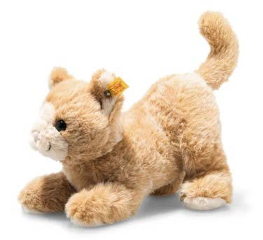 The Cassie Cat Plush Toy showcases soft, light brown fur and a white face, depicted in a playful crouched position. It includes a small yellow tag on its ear and has a curled-up tail, making it the perfect huggable companion.