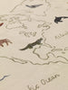 A close-up of the Ferm Living The World Textile Map - Off-white, showing an embroidered animal map of North America with stylized creatures, labeled "Atlantic Ocean," and detailed coastlines for a unique organic cotton wall decor.