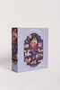 The Courting Critters 500 Piece Puzzle comes in a delightful box with pastel purple edges and a window revealing whimsical illustrations of courting animals such as rabbits, frogs, and deer. Ideal for adults or as a Valentine’s Day gift, the box features the phrases “Courting Critters” and “once upon a puzzle.”.