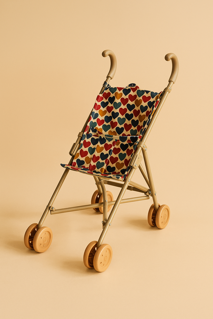 The Konges Sloejd Doll Stroller - Heart Kisses is a small beige stroller with double wheels and a fabric seat featuring a colorful heart pattern, shown against a solid light beige background.