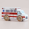 The No. 43 GT265 Lance, a wooden toy ambulance made in England and featuring red stripes, a blue emergency symbol, and sturdy wooden wheels, sits on a plain light background—ready to inspire imaginative play and endless rescue stories.