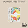 The Smoothie Fruit Wooden Market Crate, featuring colorful wooden fruit toys in recyclable packaging, is displayed against a beige background with the text “Beautifully packaged for gifting and imaginative play.” Ships in one week.
